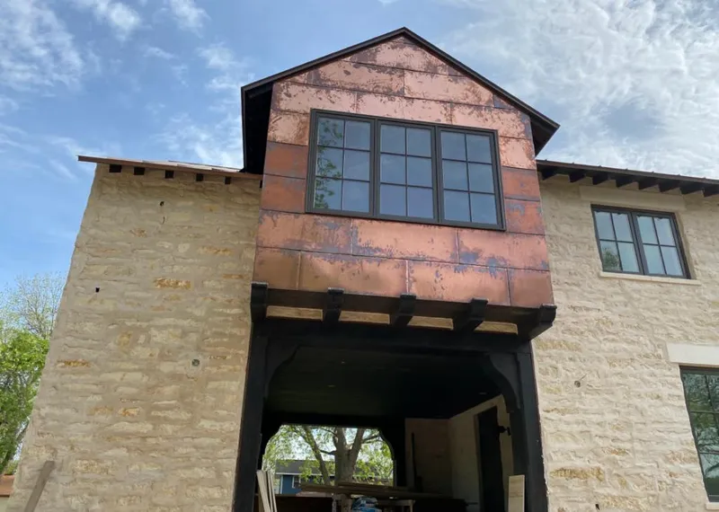 Copper metal panel facade on a stone building for Roof Repair in Spencer